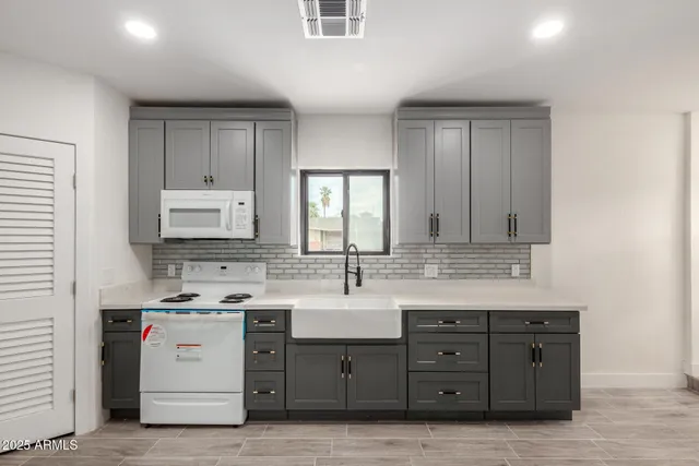 a view with cabinets a sink and a mirror