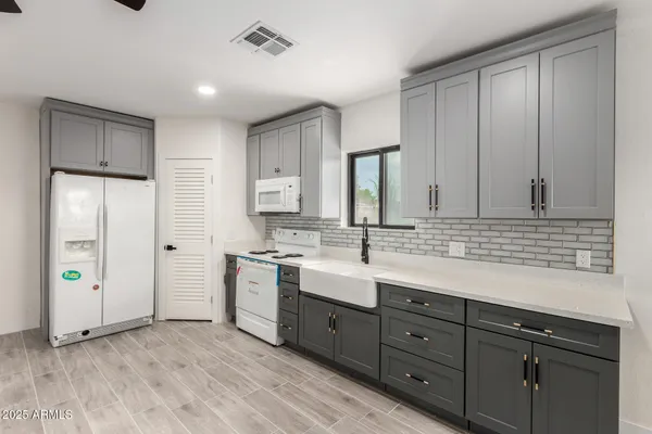a spacious bathroom with a double vanity sink a large mirror a bathtub and