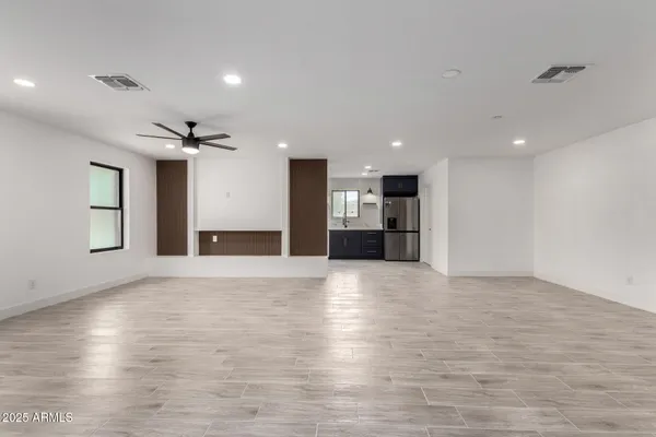 a view of empty room with kitchen and window