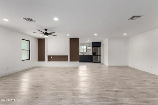 a view of empty room with kitchen and window