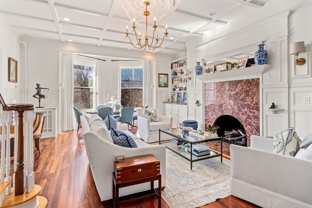 a living room with furniture a fireplace and a chandelier