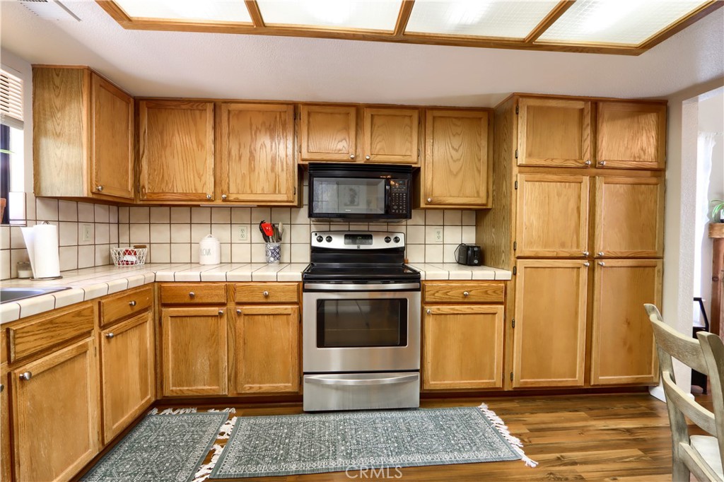 50840 Smoke Tree Trail Bass Lake, CA 93604 - Photo 17 of 36 a kitchen with stainless steel appliances granite countertop a stove a sink and a refrigerator