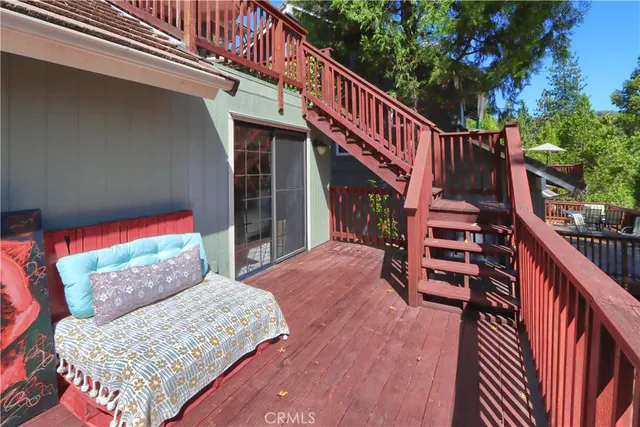 a balcony of a house with wooden floor and outdoor seating