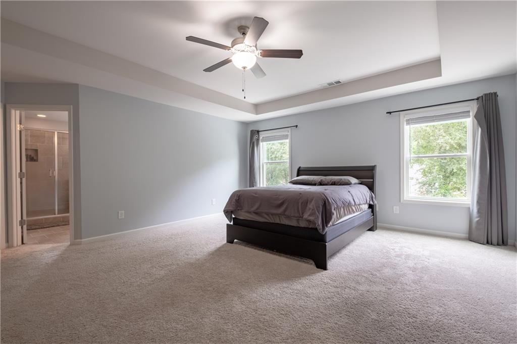 719 Fairview Road Brooks, GA 30205 - Photo 24 of 35 a spacious bedroom with a bed and a ceiling fan