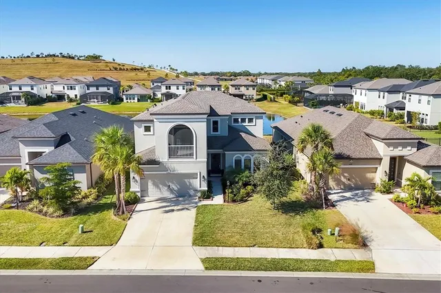 an aerial view of residential houses with outdoor space and ocean view
