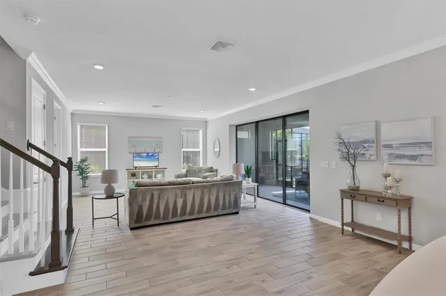 a view of a living room and kitchen with furniture wooden floor and windows