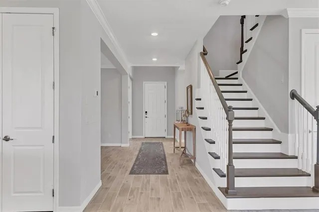 a view of a hallway with white walls and stairs