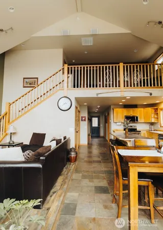 a black leather couch in a kitchen next to a large window