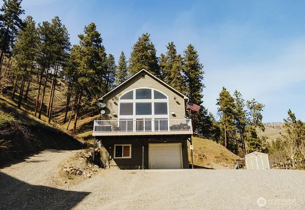 a front view of a house with a tree