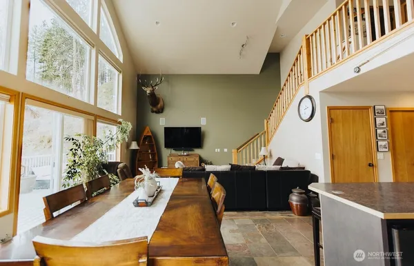 a living room with furniture a flat screen tv and large windows