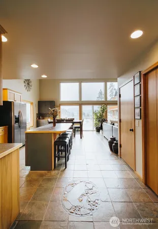 a large white kitchen with a large window and refrigerator