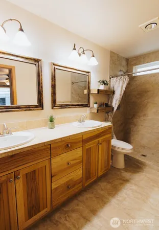 a spacious bathroom with a double vanity sink mirror and toilet