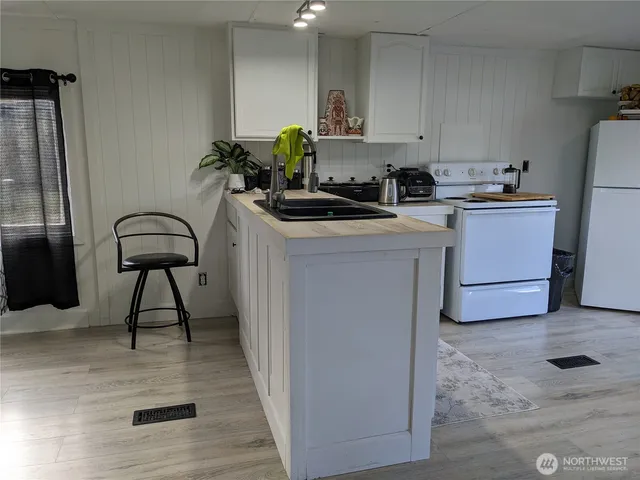 a kitchen with a cabinets a sink a counter and appliances