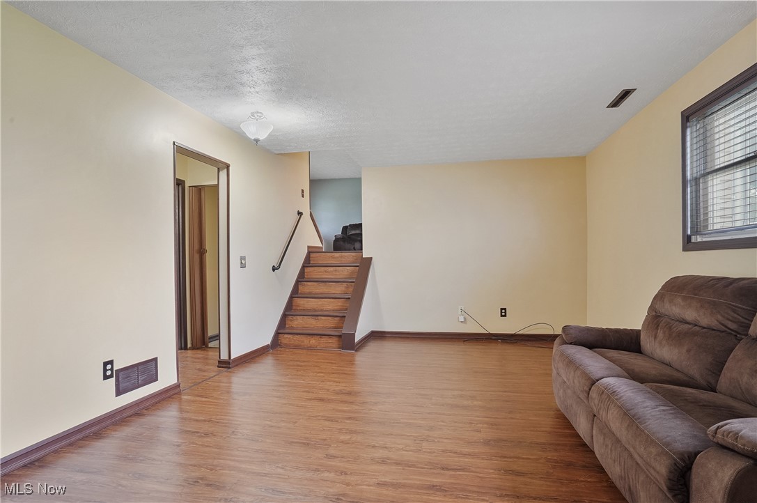 3262 Wright Road Northwest Uniontown, OH 44685 - Photo 29 of 37 Living room with wood finished floors, stairway, and a textured ceiling