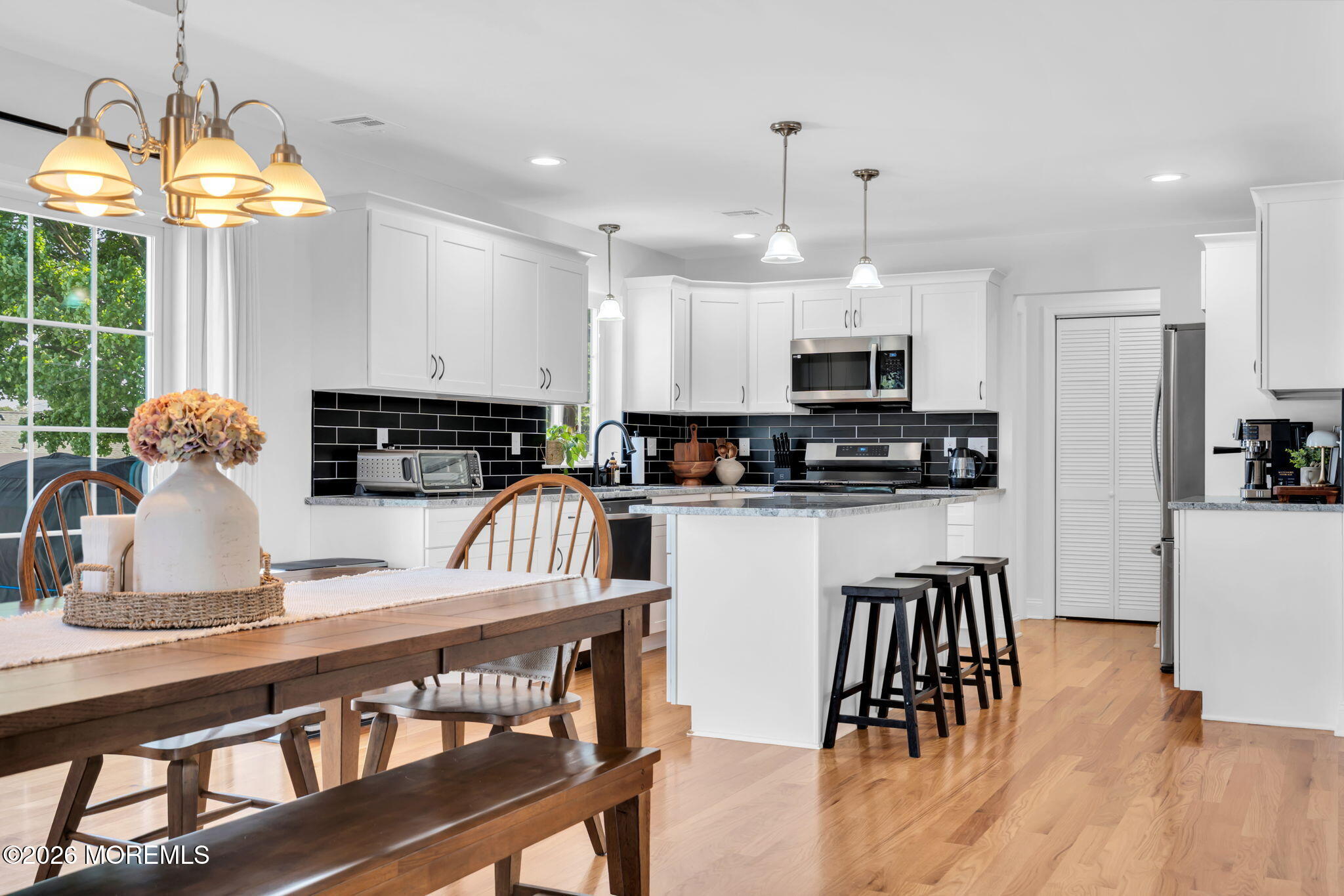312 Beach Boulevard Forked River, NJ 08731 - Photo 14 of 40 a kitchen with stainless steel appliances granite countertop a stove a sink a microwave a refrigerator cabinets and a dining table
