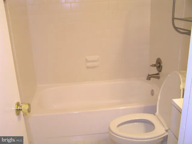 a white toilet and tub sitting next to a bathroom sink
