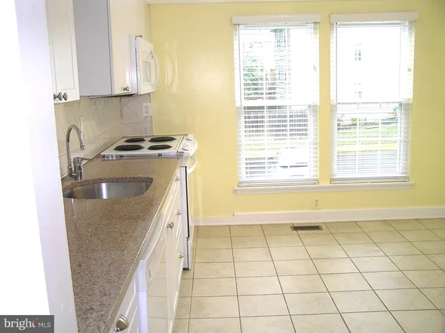 a kitchen with a sink a stove and cabinets