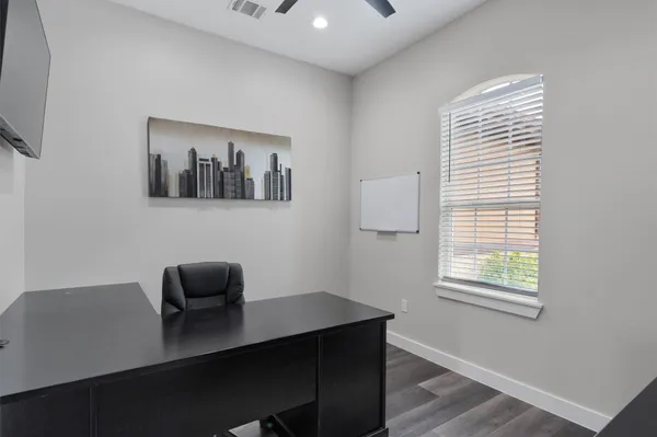 a view of a workspace with furniture and a window