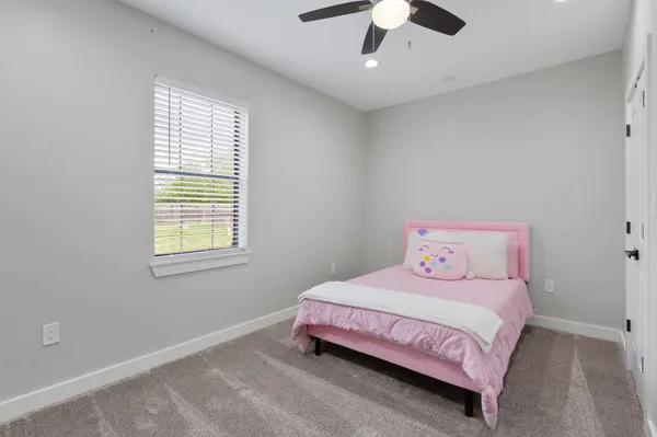 a bedroom with a bed chandelier and a window