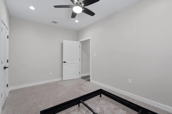 an empty room with a ceiling fan and a window