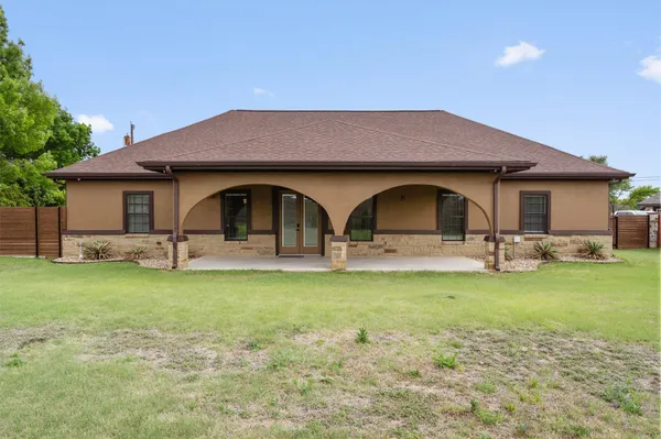 a view of a yard with a table and chairs under an umbrella