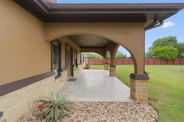 a porch with a bench and yard
