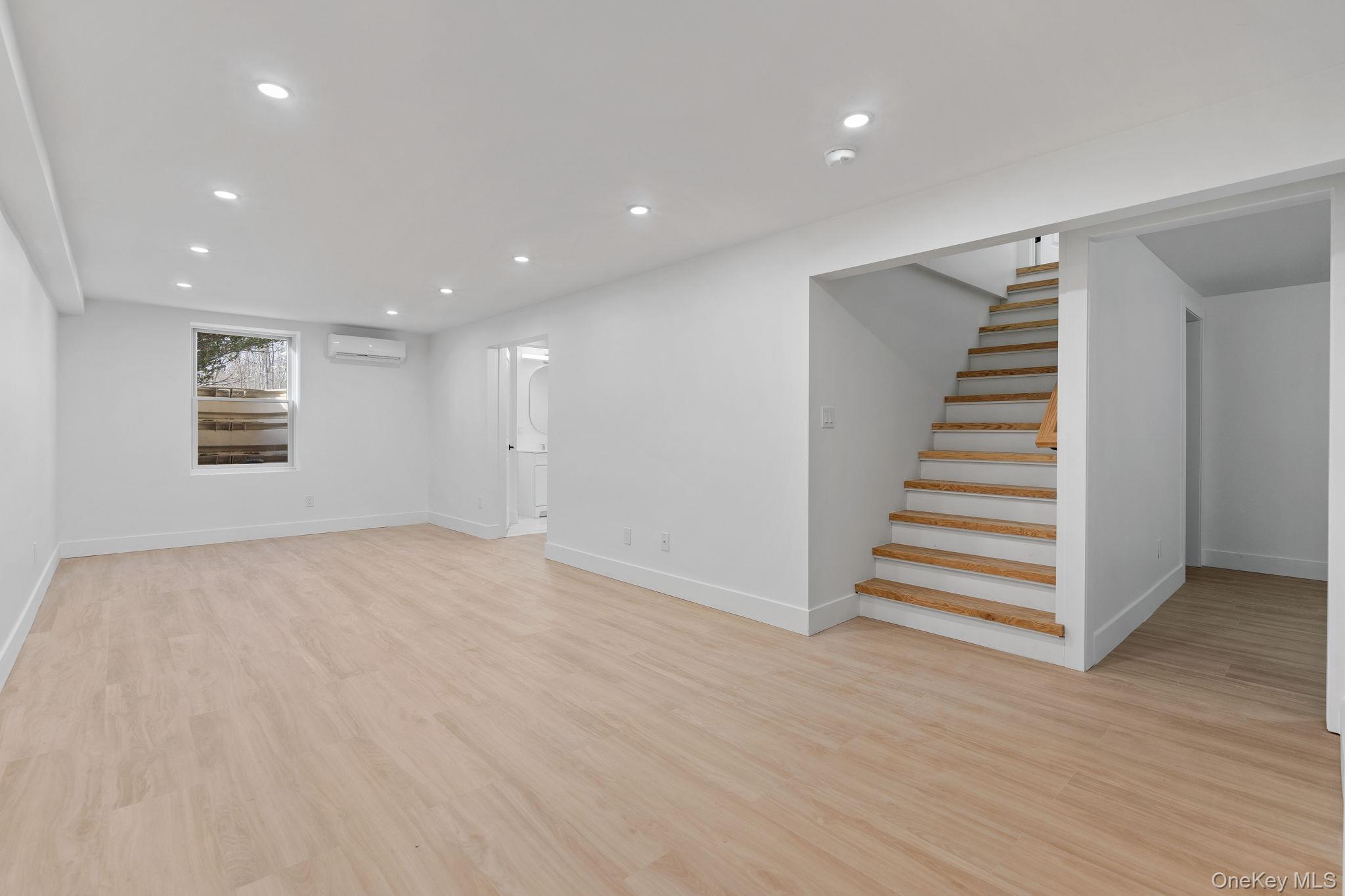52 Rudolph Road Modena, NY 12548 - Photo 30 of 49 Below grade area with recessed lighting, light wood-style flooring, stairs, and a wall unit AC