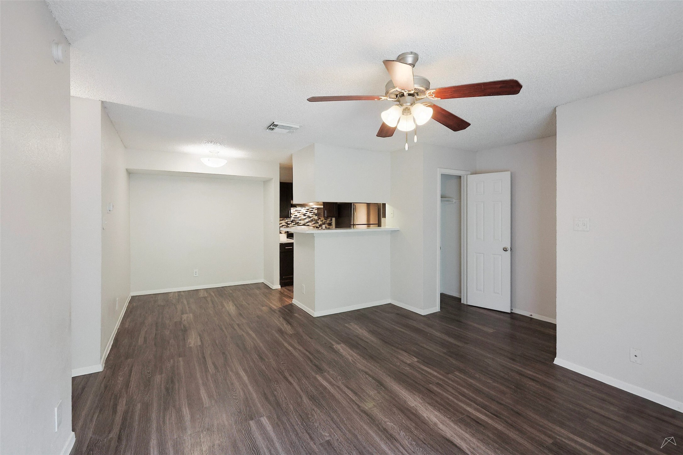 6808 South I-35 Frontage Road, Unit 202 Austin, TX 78745 - Photo 9 of 21 a view of a kitchen with wooden floor a ceiling fan and wooden floor