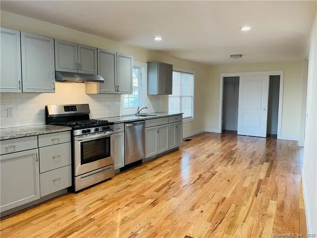 a kitchen with granite countertop a stove and cabinets