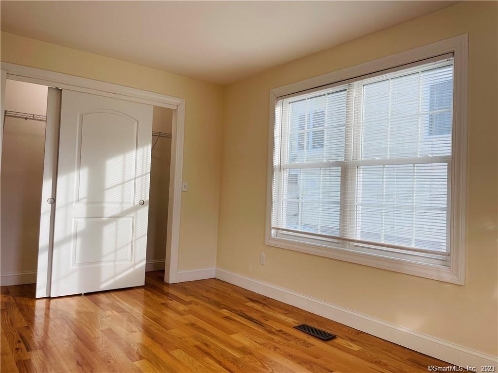31 Brainerd Road, Unit 1 Branford, CT 06405 - Photo 12 of 17 an empty room with wooden floor and windows