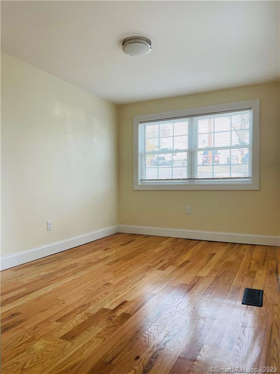 31 Brainerd Road, Unit 1 Branford, CT 06405 - Photo 14 of 17 an empty room with wooden floor and windows