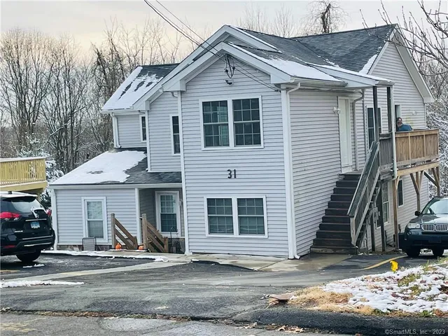 a view of a house with a yard and large tree