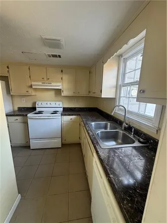 a kitchen with a stove top oven and refrigerator