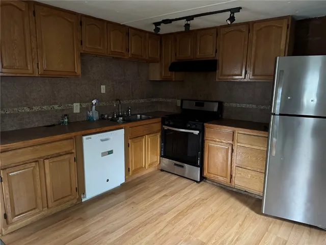 a kitchen with a refrigerator sink and cabinets