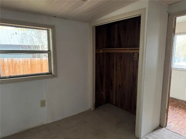 an empty room with windows and closet