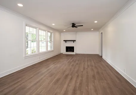an empty room with windows and fireplace