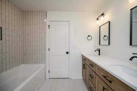 a bathroom with a tub a sink and mirror