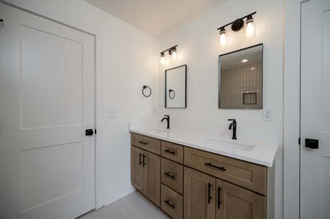 a bathroom with a double vanity sink and mirror