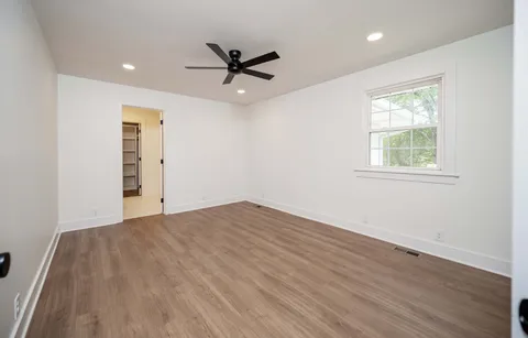a view of a big room with wooden floor closet and windows