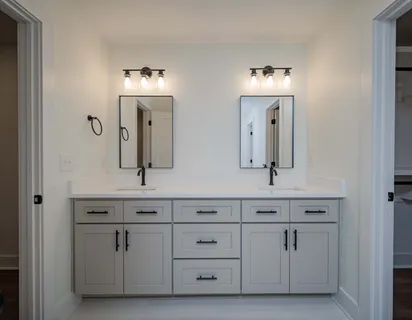 a bathroom with white cabinets and a sink
