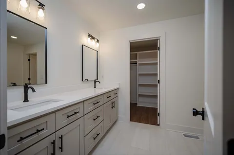 a bathroom with a double vanity sink and mirror