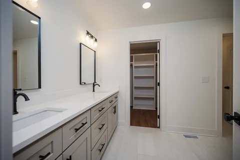 a bathroom with a double vanity sink and a mirror