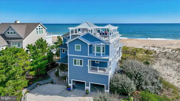 a front view of a building with lot of cars and trees