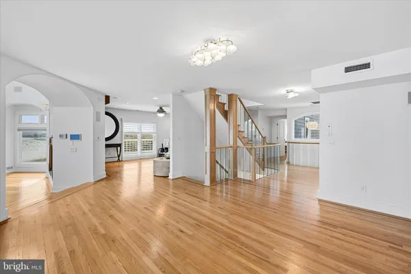 a kitchen with stainless steel appliances a refrigerator a stove a dining table and chairs with wooden floor