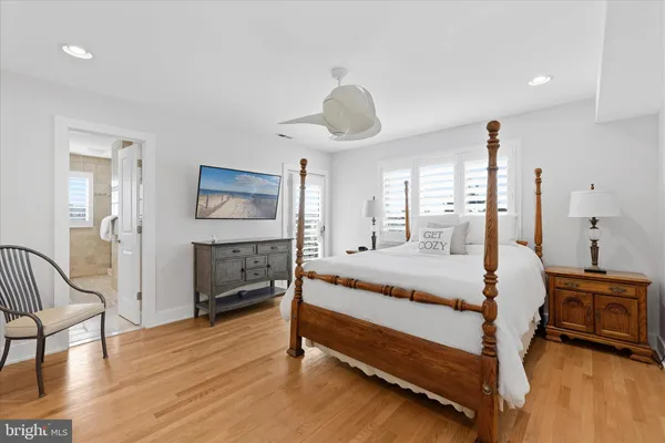 a kitchen with stainless steel appliances a refrigerator a stove a dining table and chairs with wooden floor