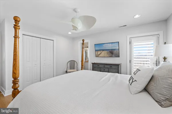 a bedroom with a bed couch chandelier and a window