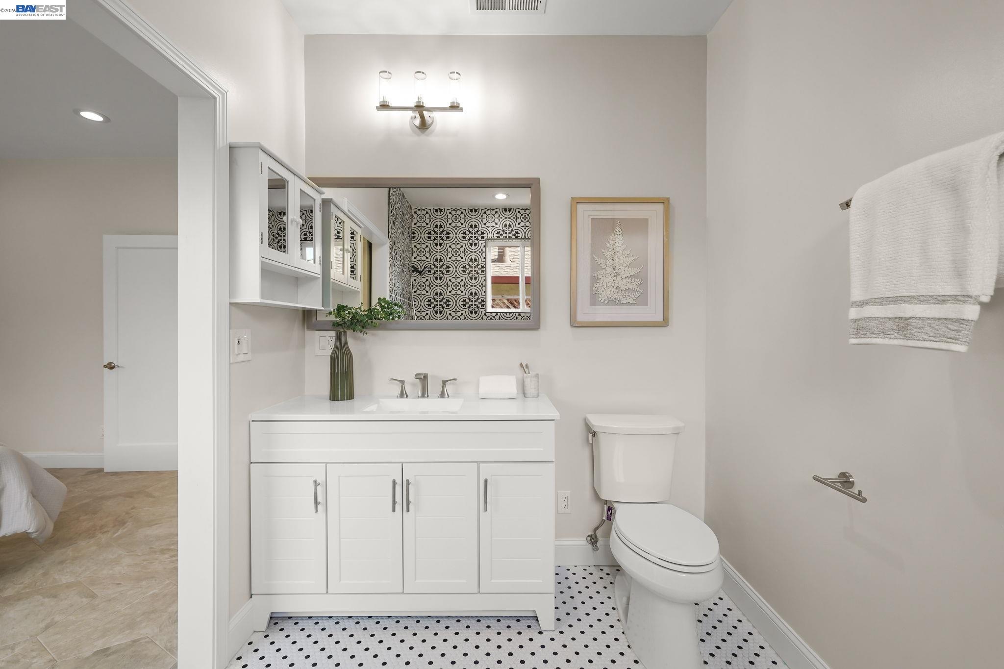 40772 Blacow Road Fremont, CA 94538 - Photo 25 of 40 a bathroom with a toilet a sink a mirror a window and vanity