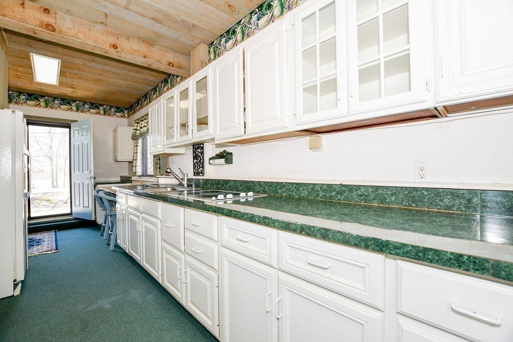 30 Clark Road Bourne, MA 02562 - Photo 31 of 40 a large white kitchen with a large window and a counter space