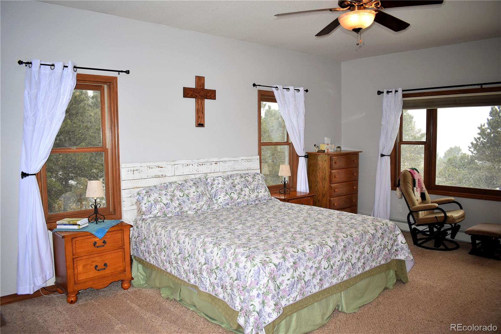 2355 Bricker Road Monument, CO 80132 - Photo 12 of 35 a bedroom with a bed and a chandelier