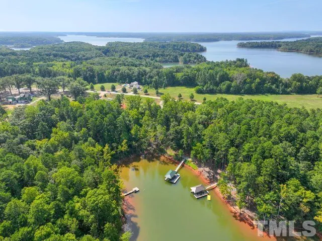 an aerial view of lake residential house with outdoor space and trees around